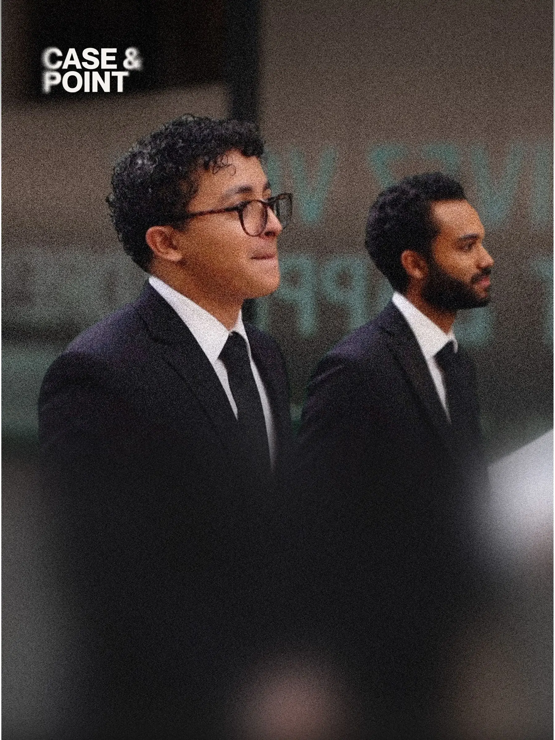 Two JMCC delegates in suits standing side by side in front of a presentation screen