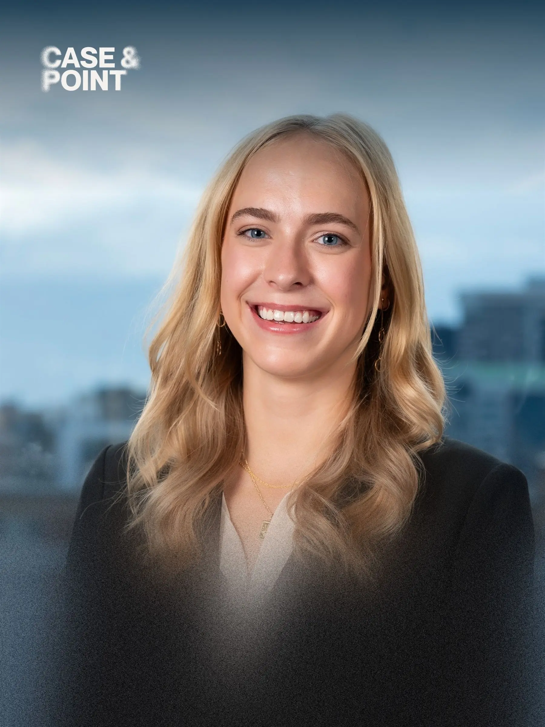 Portrait of a JMCC delegate in a dark blazer smiling, with a city skyline behind her